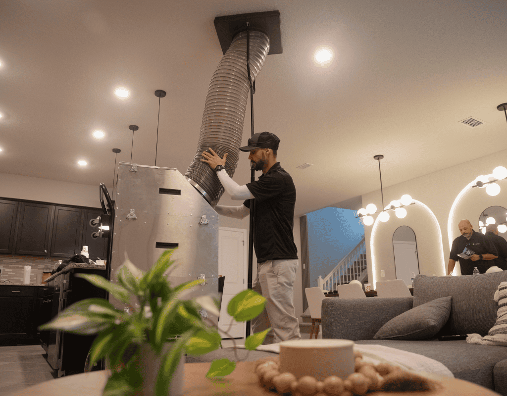 Air Titan crew member removing old duct from ceiling in a Tampa home