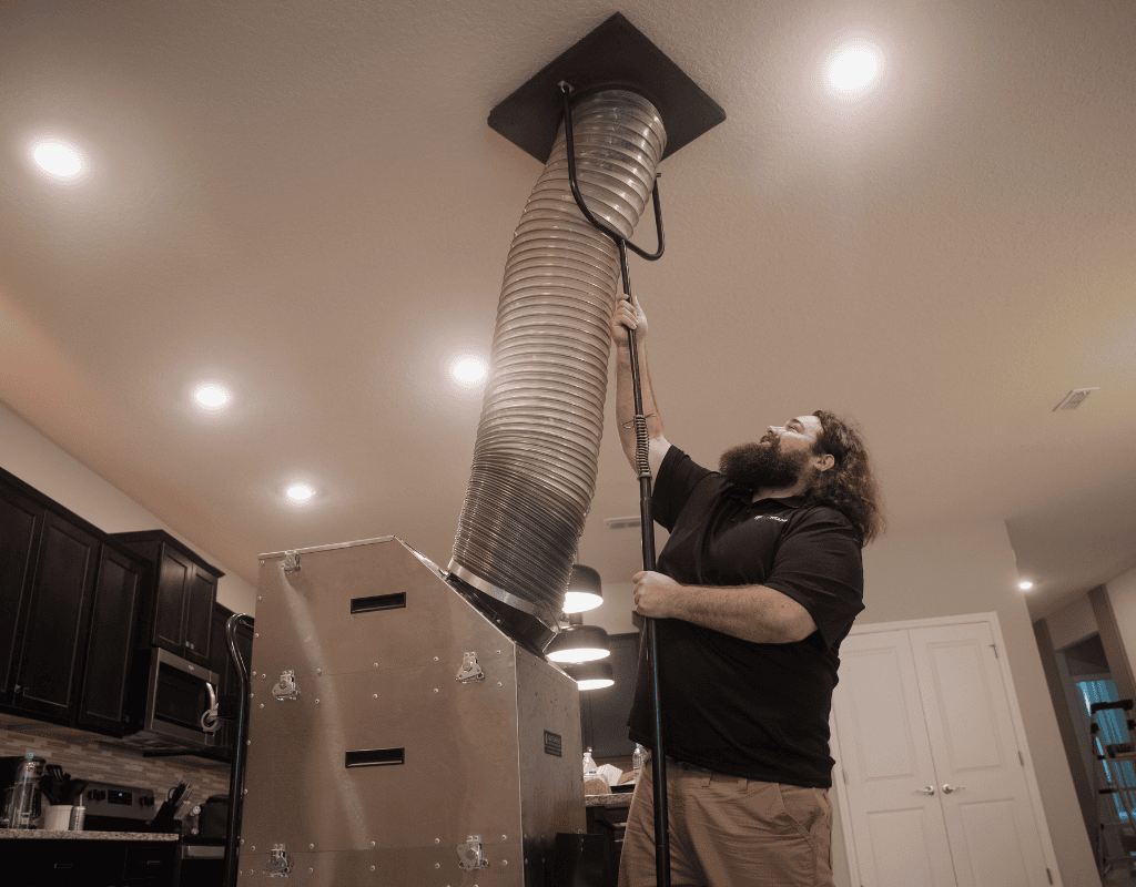Air Titans installer fitting new ductwork for an HVAC system inside a Tampa home