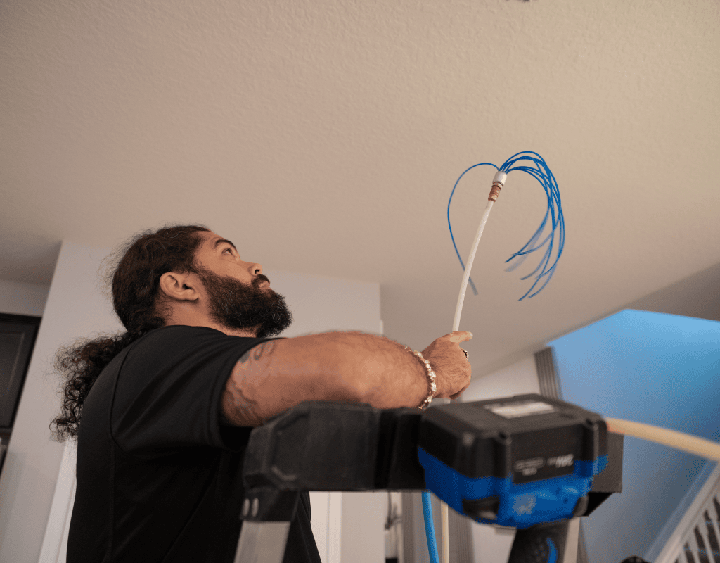 Air Titans technician routing wiring for a new HVAC installation in a Tampa residence