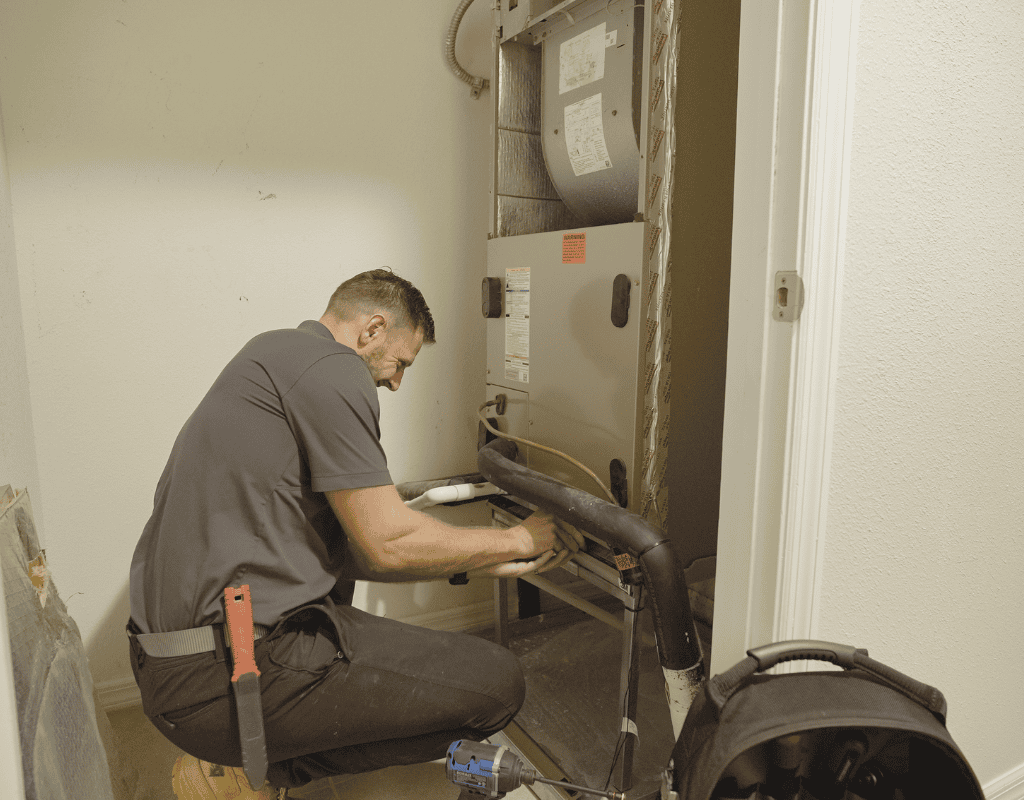 Air Titans technician inspecting HVAC unit components inside a Lutz, FL home