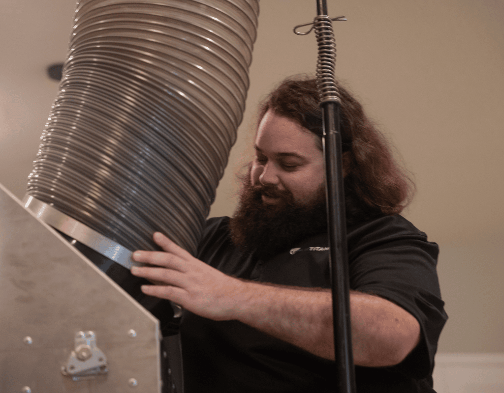 Air Titans technician operating duct cleaning machinery inside a Brandon, FL home