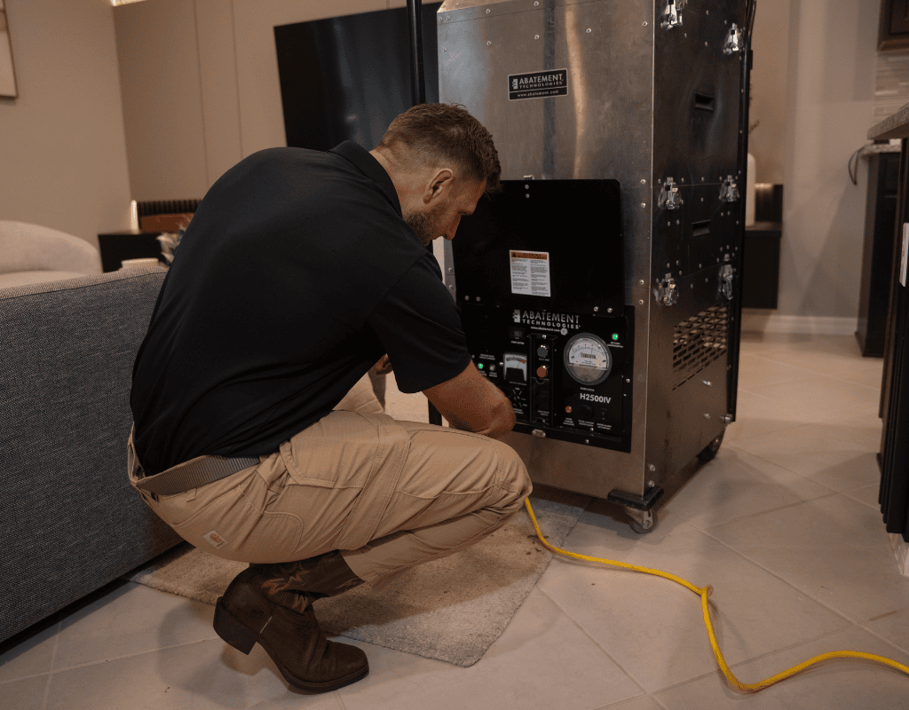 Air Titan specialist connecting thermostat and air filtration unit in a Tampa home interior